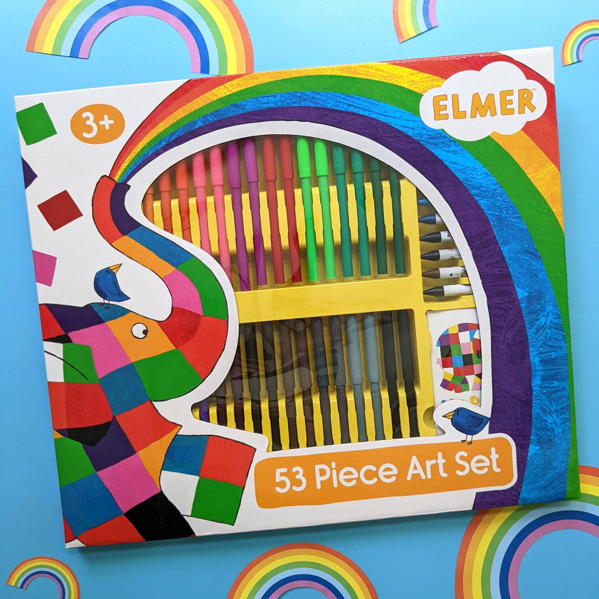 A 53-piece Elmer's art set in a colourful box with a rainbow and elephant illustration, photographed on a bright blue background with rainbow decorations.