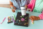 Two people using a Magic Marker to draw on a blackboard with colourful markers.