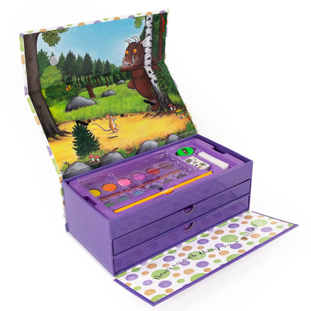 A children's wooden art and craft box set in purple, shown open with a forest illustration on the inner lid and a polka-dot patterned outer lid pulled out. Inside are paint pots, a pencil, and small accessories on a white background.