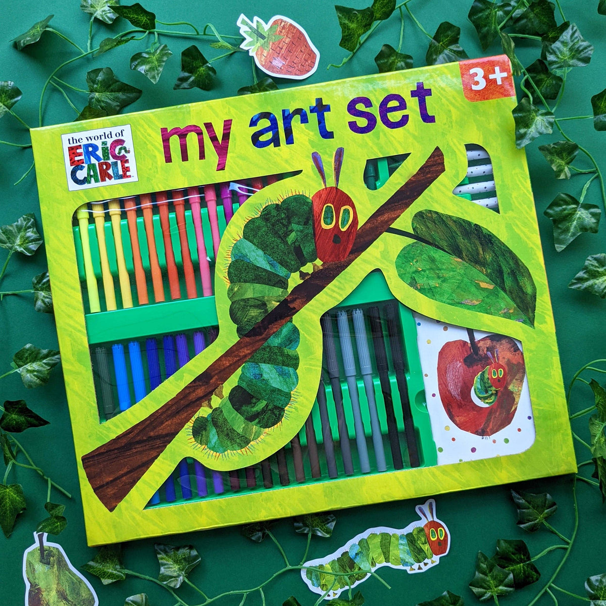 Children's art set with colorful pencils and stickers on a green leafy background, featuring 'The World of Eric Carle' branding.